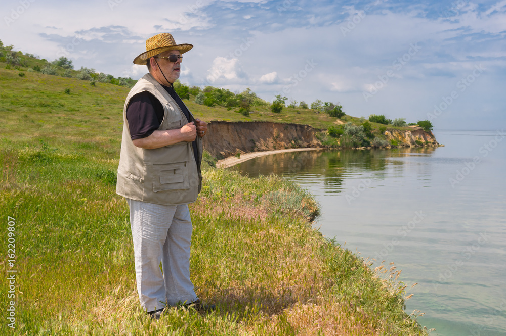 Lonely Riverside Lonely senior man standing on abrupt riverside of the Dnepr river ...