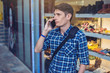 © Artem - Man traveler with backpack talking on the phone in the background of the street.