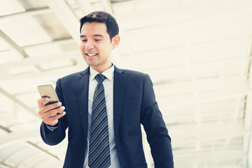 Handsome Asian businessman using smartphone