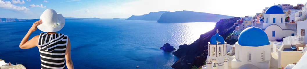 Woman with hat watching Oia village on santorini island in Greece