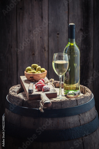 Plakat Wino Chardonnay, oliwki i wędliny na beczce dębowej
