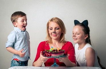 Little boy with mum and sister with birthday cake