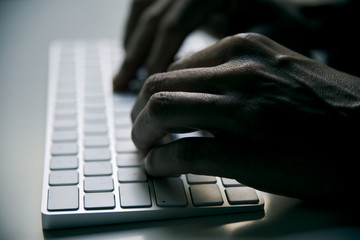 young man typing in a computer keyboard