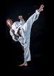 © Andriy Petrenko - Young athlete in a kimono on a dark background