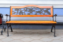 An Empty Wrought Iron Bench With Wood Accents Against Blue Walls