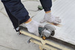 © sima - Cutting of heat insulated galvanized corrugated sandwich roof or wall panel, worker use angle grinder tool