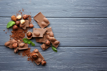 Wall Mural - Dark chocolate pieces on wooden table