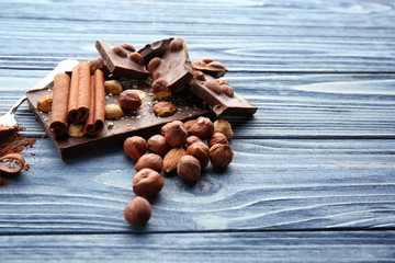 Wall Mural - Dark chocolate pieces with cinnamon on wooden table