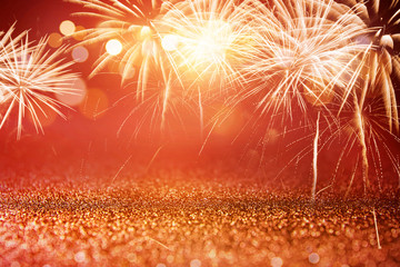 Wall Mural - holiday red and gold fireworks and bokeh in new year eve and copy space. abstract background celebra