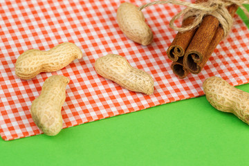 Wall Mural - Cinnamon sticks and raw peanuts on a bright background