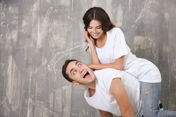 Wall Mural - Beautiful young couple on grunge wall background