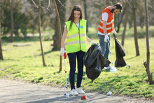 Young Volunteer Picking Up Litter In Park