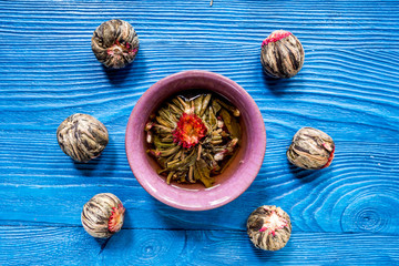 Wall Mural - herbs in colorful bowls to make tea on blue table background top view mock-up