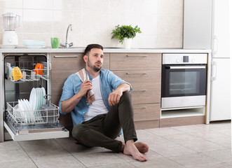 Wall Mural - Tired man beside open dishwasher