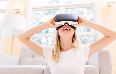 Wall Mural - Happy young woman using a virtual reality headset