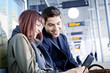 © Lumi Images - Young couple in airport building using digital tablet