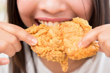 Young Woman Eating Deep Fried Chicken - Close Up Shot