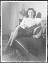Woman Reads On Sofa. Date: 1940s