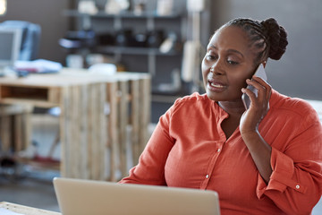 Wall Mural - Young African businesswoman hard at work in a modern office