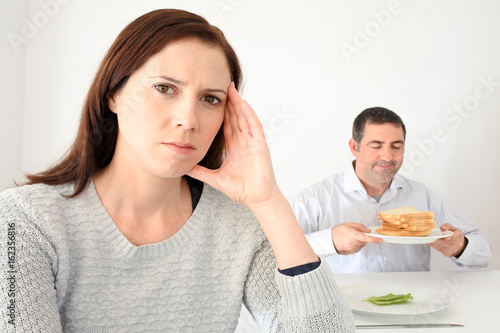 Fotografía Young woman upset when her partner eat and enjoys carbohydrates
