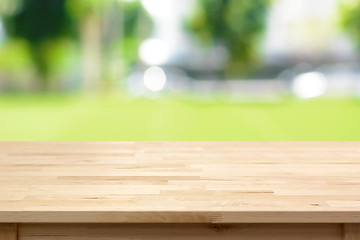 Wall Mural - Wood table top on blurred green yard background