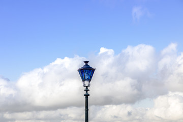 Blue street lamp french old style on blue sky and white clouds background