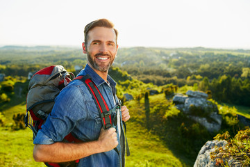 Wall Mural - Happy middle-aged man hiking and enjoying the mountain landscape