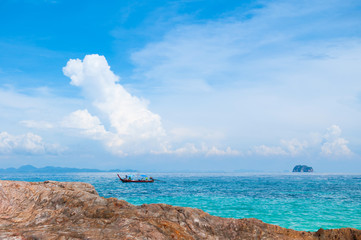 Wall Mural - Rock Beach with crystal clear water and boat