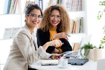 Two businesswoman working with laptop in her office.