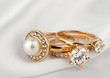 jewelry rings with diamonds and pearl on white cloth, soft focus