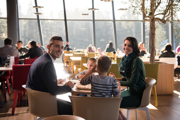 Young parents enjoying lunch time with their children