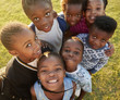 © Monkey Business - Elementary school kids in a field look up at  camera smiling
