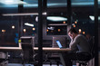 © .shock - man working on laptop in dark office