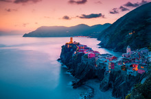 View Of Famous Travel Landmark Destination Vernazza,small Mediterranean Old Sea Town With Harbour Coast And Castle,Cinque Terre National Park,Liguria, Italy. Summer Colorful Sunset With Street Lights