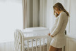 Pregnant woman setting up baby crib