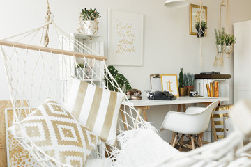 White hammock with golden pillows