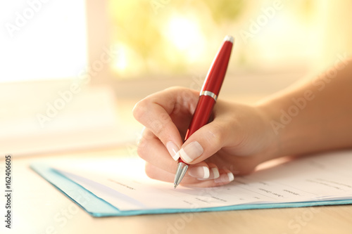 Fotomural Woman hand filling form on a table