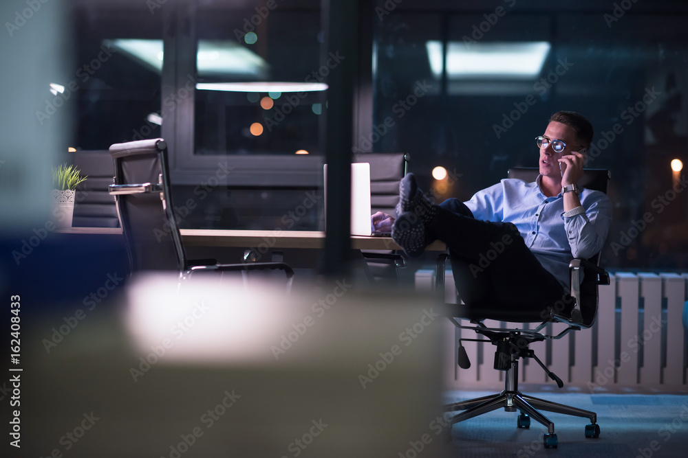 businessman using mobile phone in dark office - obrazy, fototapety, plakaty 