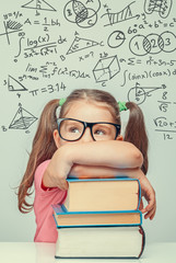 Wall Mural - beautiful cute little genius girl with books. Math formulas, problems over her head