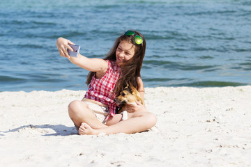 Poster - girl and dog make selfie on phone on the beach