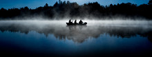 Silhouette Of Fisherman On Misty Blue Lake