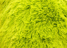 Fluffy Texture Fabric. Closeup Of The Pillow With Green Fur Cover. Abstract Background.