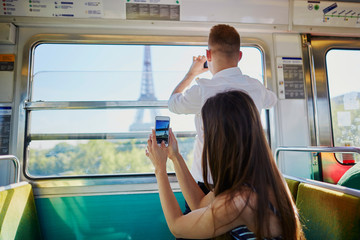 Wall Mural - Couple traveling in subway train with view to the Eiffel tower