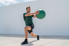 Working Out Man Training Legs And Core Ab Workout Doing Lunge Twist Exercise With Medicine Ball Weight. Gym Athlete Doing Lunges And Torso Rotations For Abs Training.