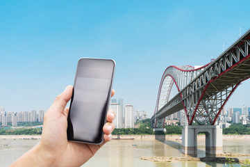 Wall Mural - mobile phone with steel bridge over river