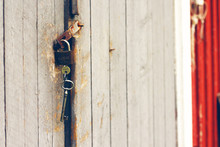 Old Rusty Padlock With Keys On Wooden Barn Door
