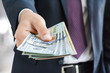 © Atstock Productions - Businessman giving money, united states dollar (USD) bills