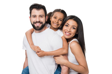 man and daughter piggybacking while woman standing near by isolated on white