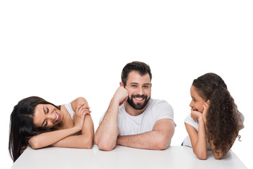 Wall Mural - Happy multiethnic family sitting together and smiling isolated on white