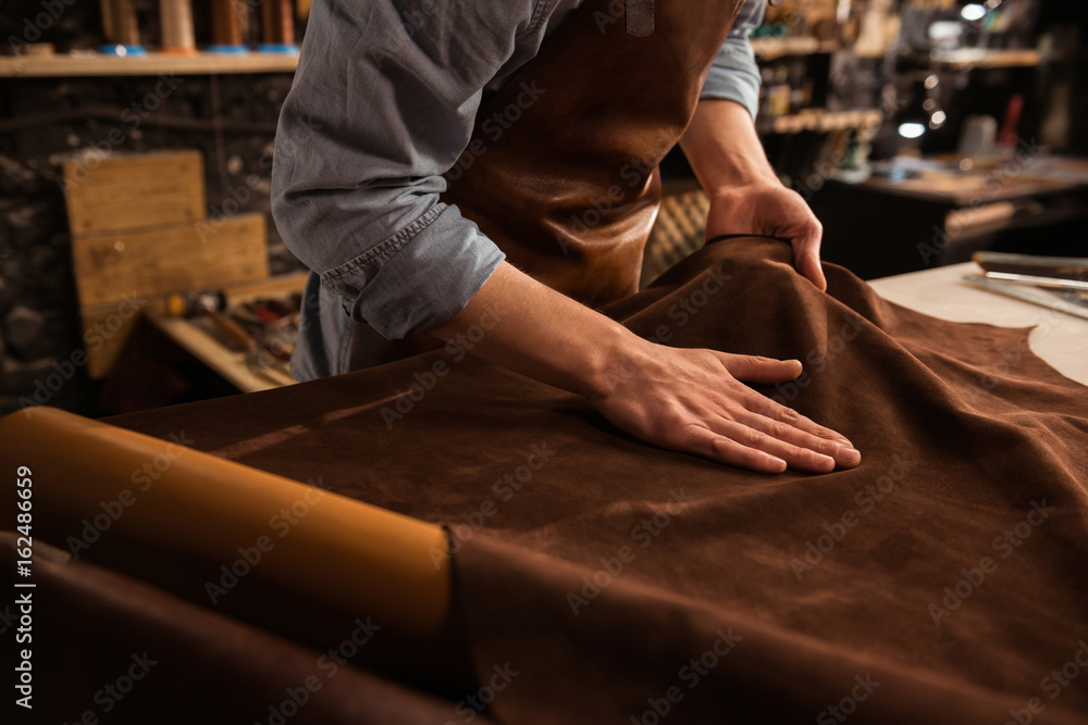 Close up of a cobbler working with leather textile - obrazy, fototapety, plakaty 